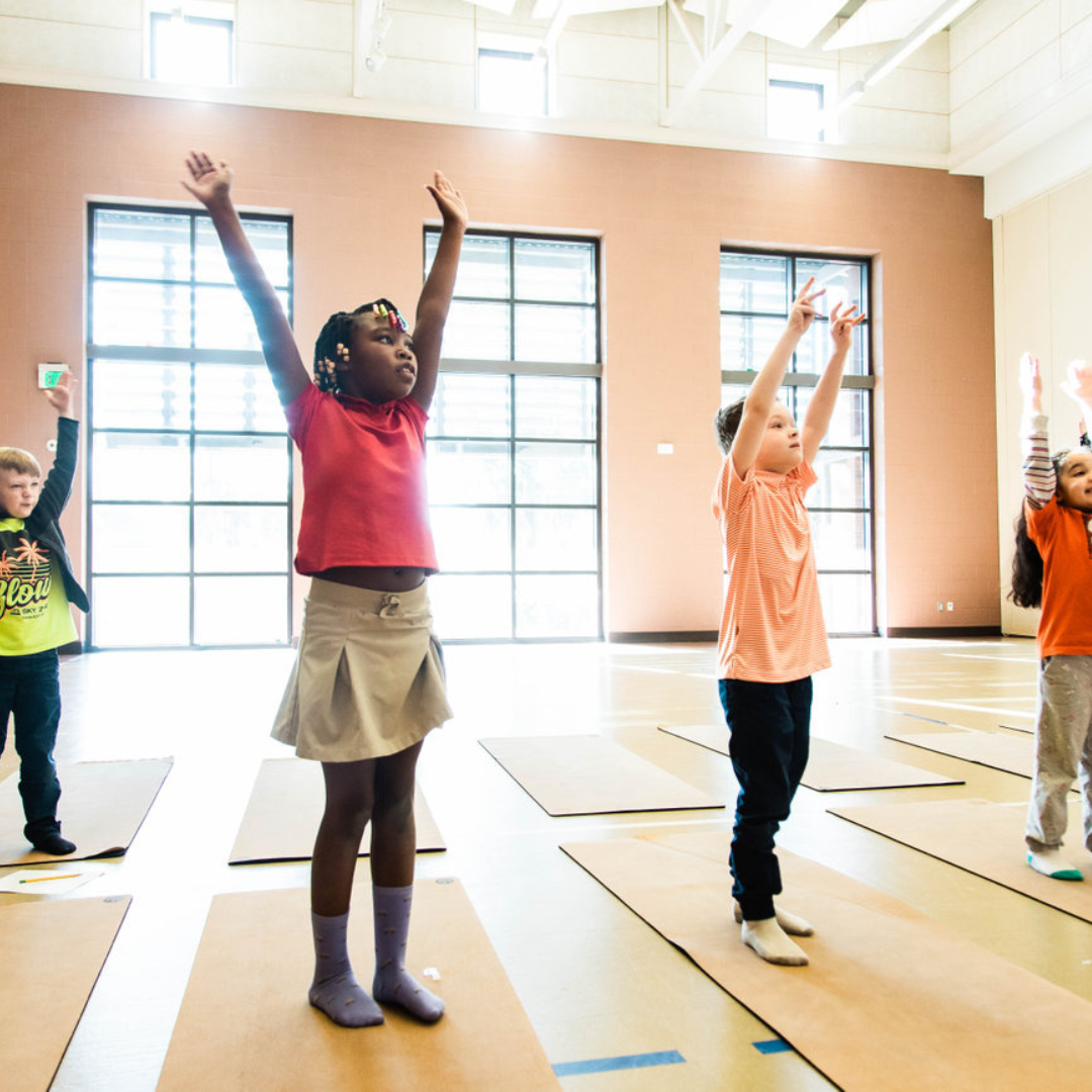 Kids following yoga steps together