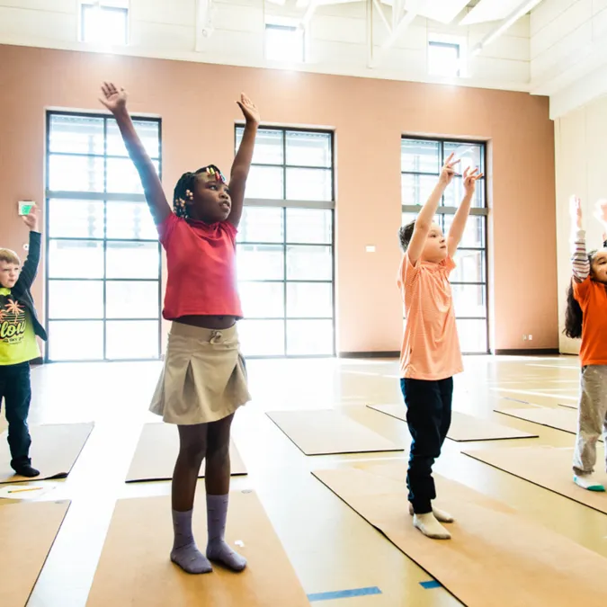 Kids following yoga steps together